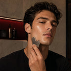 AscendLab Stainless Steel Gua Sha — młody mężczyzna masujący linię żuchwy