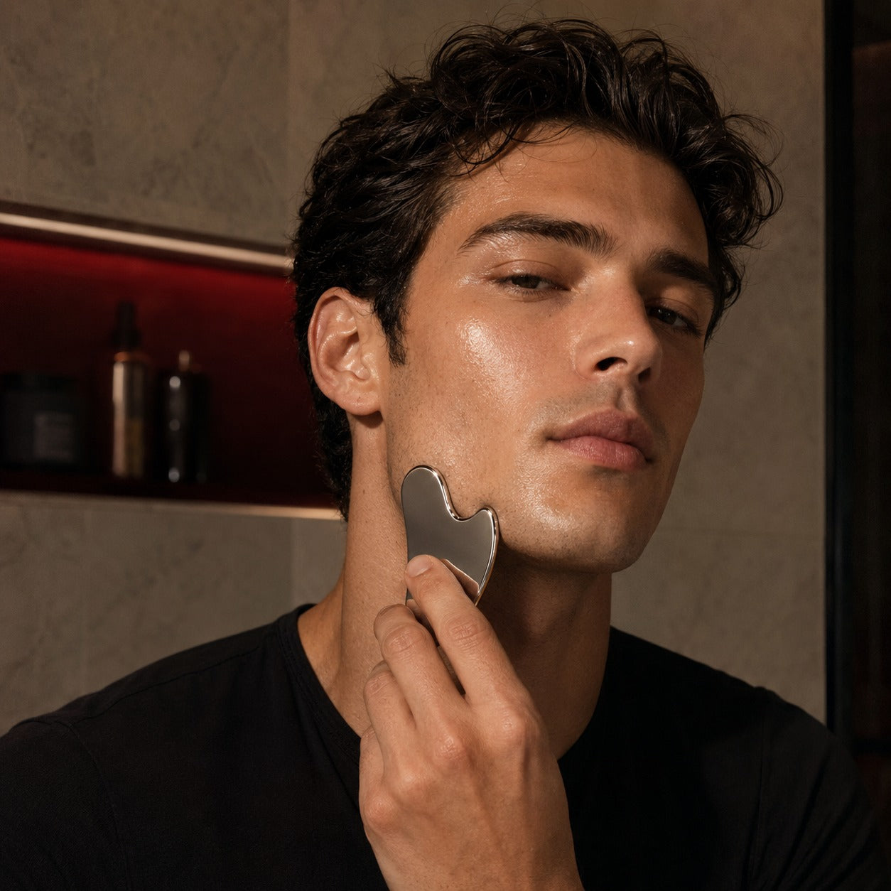 AscendLab Stainless Steel Gua Sha — młody mężczyzna masujący linię żuchwy